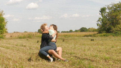 Beautiful Teen Couple in Love Passionately Kissing on the field